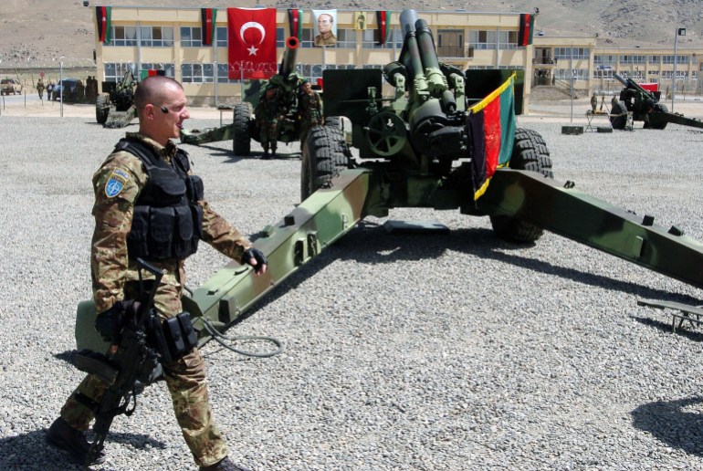 A soldier with the NATO-led International Security Assistance Force (ISAF) walks past howitzer artillery guns donated by the Turkish military at a ceremony in Kabul, 09 May 2007. The Turkish force, which has 1,1150 people serving with the NATO-led International Security Assistance Force (ISAF), donated 24 howitzers and related material to the Afghan army, which is rebuilding after being destroyed during Afghanistan's years of war. AFP PHOTO/SHAH Marai (Photo by SHAH MARAI / AFP)