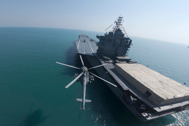 In this image provided Thursday, Feb. 6, 2025, by Sepahnews of the Iranian Revolutionary Guard, a helicopter flies over Iran's first drone-carrier warship in the Persian Gulf. (Sepahnews via AP)