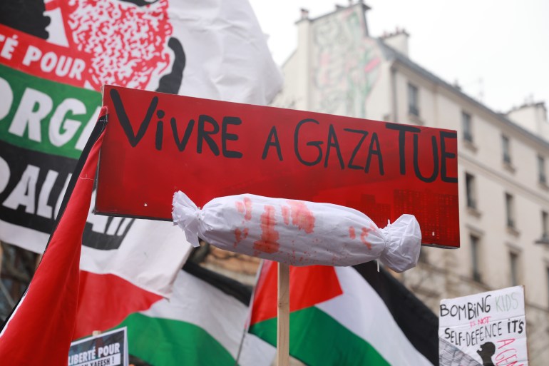 PARIS, FRANCE - MARCH 22: A protest sign reading 'Vivre a Gaza tue' (Living in Gaza kills) is seen during a demonstration marking the International Day for the Elimination of Racial Discrimination in Paris, France, on March 22, 2025. Thousands gathered in solidarity with Palestinians and to protest racial discrimination and injustice worldwide. (Photo by Mohamad Salaheldin Abdelg Alsayed/Anadolu via Getty Images)