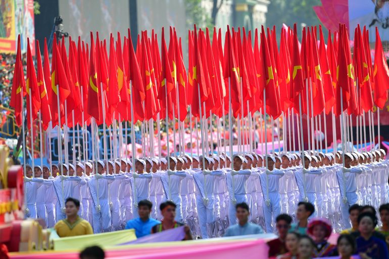 epa12064002 People holding flags march during a parade marking the 50th anniversary of the Liberation of the South and National Reunification Day, in Ho Chi Minh City, Vietnam, 30 April 2025. Vietnamese Reunification Day is observed annually on 30 April. EPA-EFE/STRINGER
