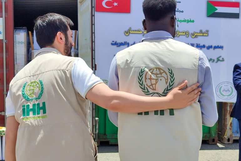 السودان يستقبل مساعدات إنسانية جديدة من تركيا 1 إثنين من العاملين يرتديان شعار هيئة الإغاثة التركية