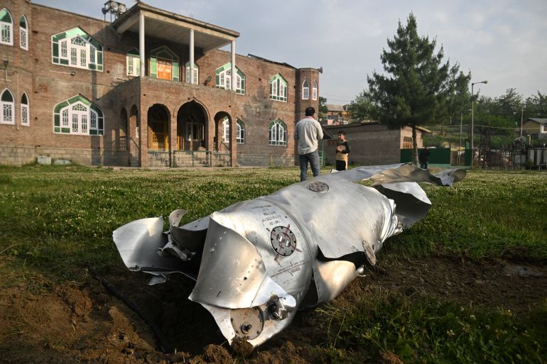 بالصور.. تصعيد جديد يعيد شبح المواجهة بين الهند وباكستان 12 People stand near a part of an aircraft in Wuyan near Indian-administered Kashmir's main city of Srinagar on May 7, 2025.