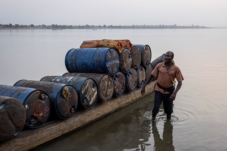غاز ورشاوى وصمت مدو.. حين فتحت الكونغو أبواب أفريقيا أمام "إيني" الإيطالية 1 A man stands next to a pirogue full of empty barrels headed for the Democratic Republic of Congo (DRC) to collect palm oil in Bangui, on February 27, 2025. (Photo by PATRICK MEINHARDT / AFP)