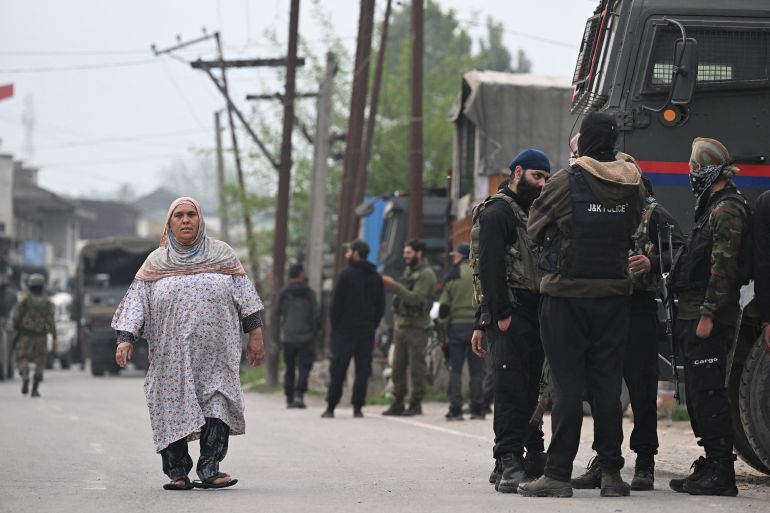 بالصور.. تصعيد جديد يعيد شبح المواجهة بين الهند وباكستان 7 Indian security personnel stand guard as a woman walks along a road in Wuyan near Indian-administered Kashmir's main city of Srinagar on May 7, 2025.