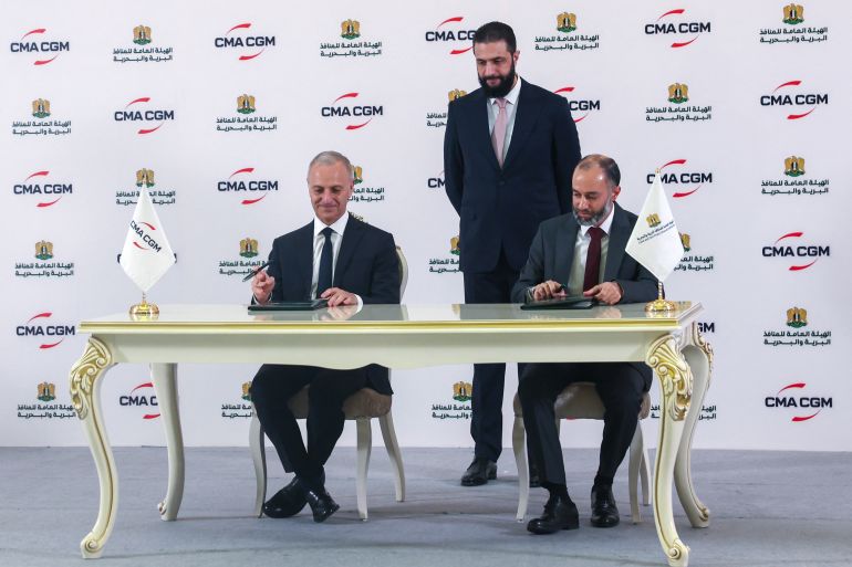 بوادر انفتاح أميركي على سوريا وسط ترقب لزيارة ترامب للمنطقة 1 Syrian President Ahmed al-Sharaa (C) looks on as Joseph Dakak, the regional director of French shipping company CMA GGM, (L) and Latakia port director Ahmed Mustafa sign an agreement in Damascus on May 1, 2025.