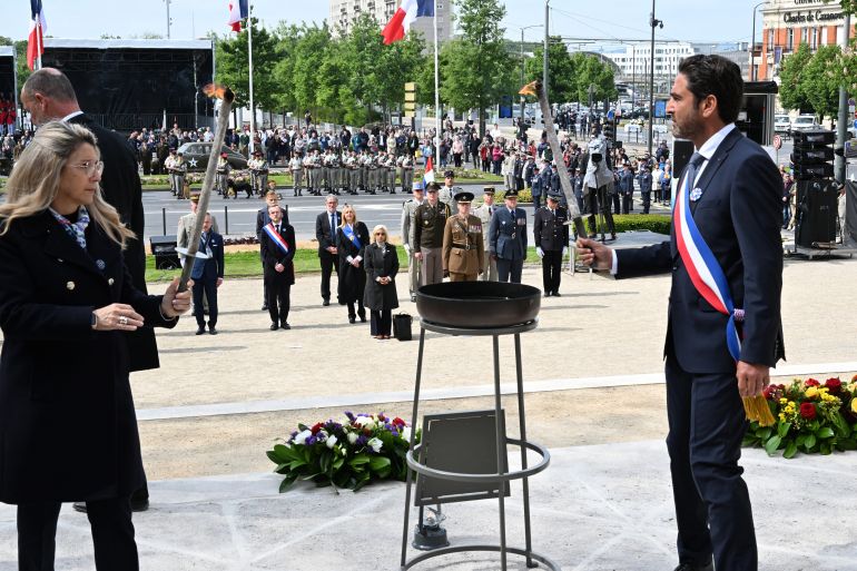 بالصور.. روسيا وأوروبا تحييان ذكرى الانتصار على النازية 15 France's Delegate Minister to Memory and Veterans Affairs Patricia Miralles (L) and Reims mayor Arnaud Robinet light the flame of remembrance during the Commemoration of the 80th anniversary of the end of World War II in Europe, in Reims, north eastern France, where Nazi Germany signed its initial 1945 surrender, on May 7, 2025.