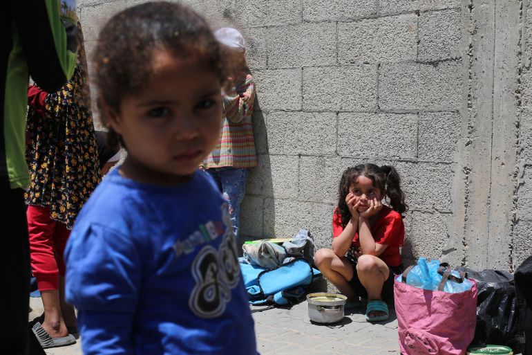 غزة تُعلن رسميا "منطقة مجاعة" جراء الحصار الإسرائيلي 9 Palestinian children wait near a charity kitchen distributing portions of cooked food at the Nuseirat refugee camp in the central Gaza Strip on May 5, 2025.