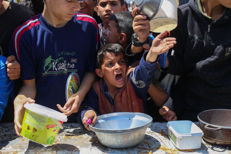 غزة تُعلن رسميا "منطقة مجاعة" جراء الحصار الإسرائيلي 6 A Palestinian boy gestures as he waits for a portion of hot food distributed by a charity kitchen at the Nuseirat refugee camp in the central Gaza Strip on May 5, 2025.