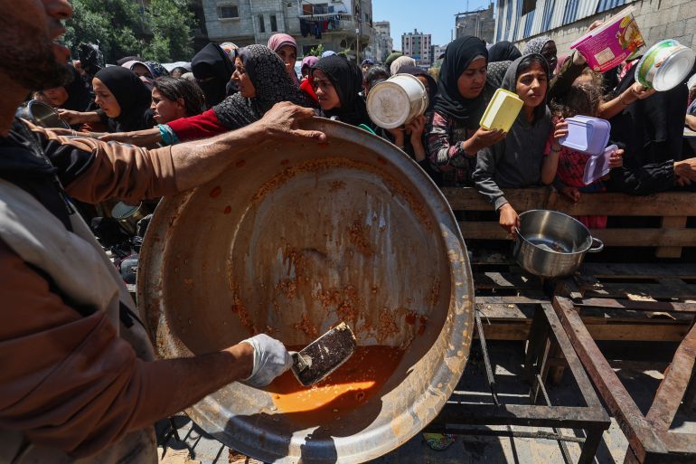 غزة تُعلن رسميا "منطقة مجاعة" جراء الحصار الإسرائيلي 1 Palestinians queue for a portion of hot food distributed by a charity kitchen at the Nuseirat refugee camp in the central Gaza Strip on May 5, 2025.