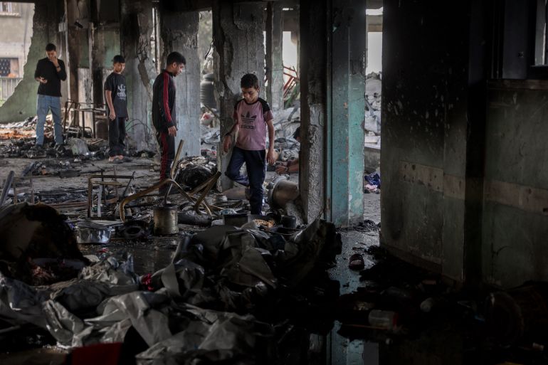 إسرائيل أحرقت النازحين نياما في مجزرة حي الدرج 3 Palestinian youths look for salvageable items amid the debris after an Israeli airstrike hit the Mussa bin Nusseir UNRWA school, serving as a shelter for people who left their homes in the besieged Palestinian territory, in Gaza City's Daraj district on May 20, 2025.