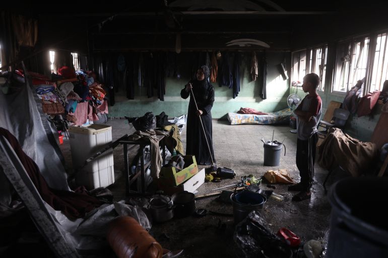 إسرائيل أحرقت النازحين نياما في مجزرة حي الدرج 6 A Palestinian woman sweeps the floor inside a classroom after an Israeli airstrike hit the Mussa bin Nusseir UNRWA school, serving as a shelter for people who left their homes in the besieged Palestinian territory, in Gaza City's Daraj district on May 20, 2025.