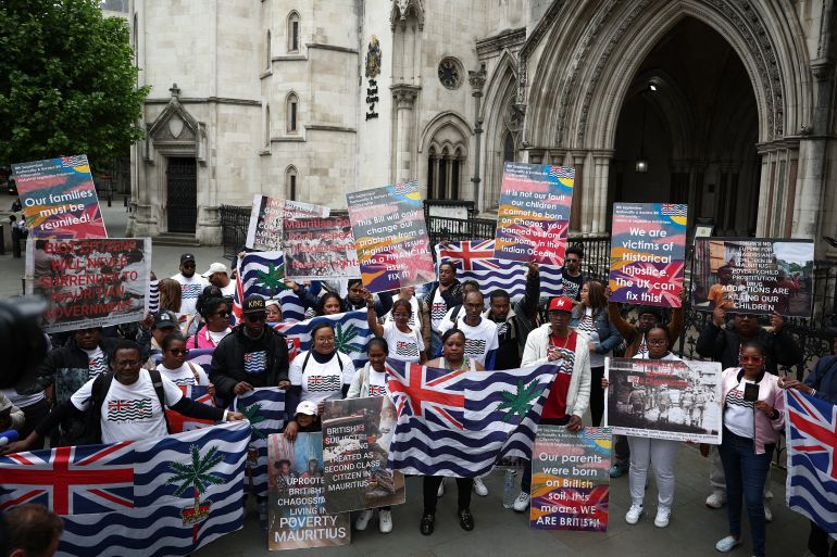 معركة الوثائق السرية في مواجهة التاريخ الاستعماري المظلم لبريطانيا 2 Members of the Chagossian community and supporters pose for a photo outside the High Court in London on May 22, 2025, as a hearing into the fate of the Chagos Islands, goes on inside.