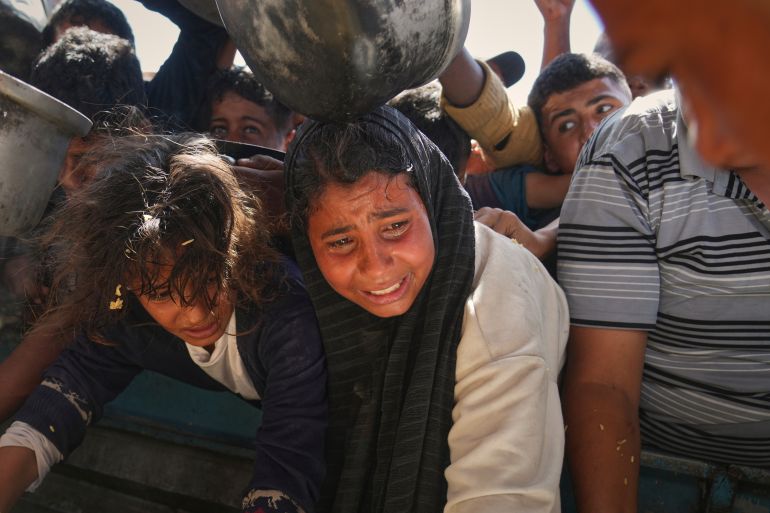 غزة تُعلن رسميا "منطقة مجاعة" جراء الحصار الإسرائيلي 10 Palestinians struggle to obtain donated food at a community kitchen in Khan Younis, in the southern Gaza Strip, Friday, May 9, 2025. (AP Photo/Abdel Kareem Hana)