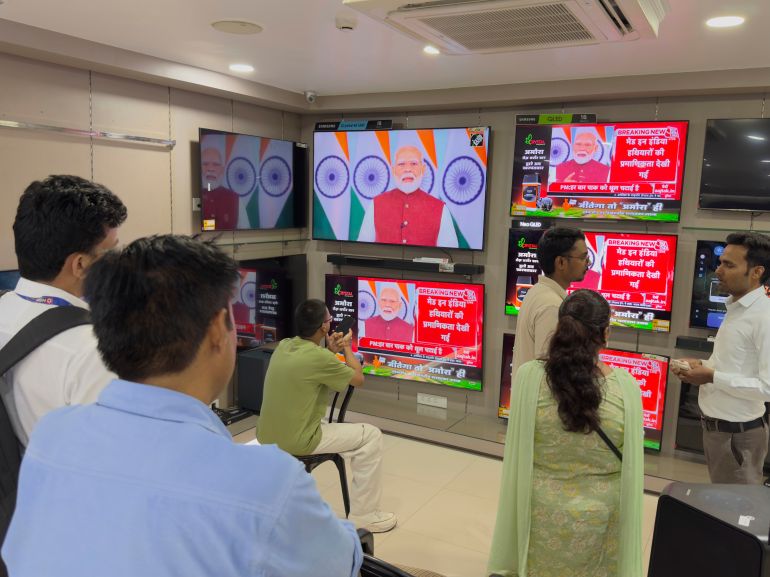 الهدوء يسود بين الهند وباكستان ومودي يتوعد 2 Indians watch the live telecast of Indian Prime Minister Narendra Modi's speech on television screens, in Prayagraj, in the northern Indian state of Uttar Pradesh, India, Monday, May 12, 2025. (AP Photo/Rajesh Kumar Singh)
