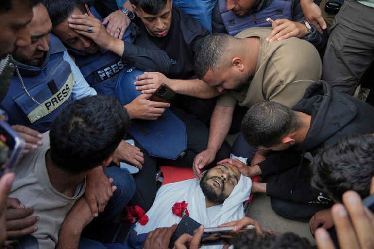بالصور.. مستشفى ناصر الطبي يُقصف بمرضاه 4 Colleagues mourn over the body of Palestinian journalist Hassan Essliah during his funeral, after he was killed in an overnight Israeli army strike on Nasser Hospital in Khan Younis, Gaza Strip, Tuesday, May 13, 2025. (AP Photo/Jehad Alshrafi)