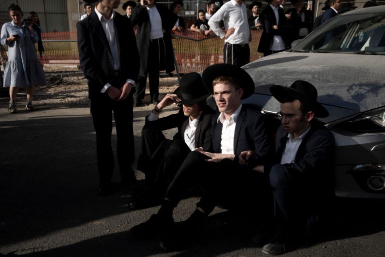 حملة لاعتقال الحريديم الفارين من الخدمة وقادتهم يهددون بإسقاط الحكومة 3 Ultra-Orthodox Jewish men block a car from crossing Jaffa Street in central Jerusalem, Thursday, Sept. 29, 2022 to protest attempts to force them to register for Israel's military draft. Military service is mandatory for most Jewish Israeli men, but the ultra-Orthodox often receive exemptions in order to continue their religious studies. (AP Photo/ Maya Alleruzzo)
