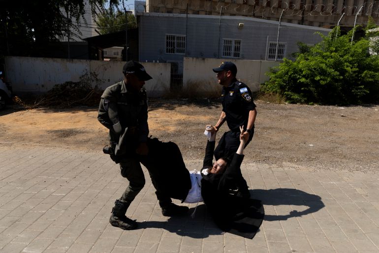 حملة لاعتقال الحريديم الفارين من الخدمة وقادتهم يهددون بإسقاط الحكومة 2 RAMAT GAN, ISRAEL - AUGUST 5: Police officers disperse an an Ultra Orthodox Jewish protester during a demonstration against drafting to the Israeli military near a recruitment base on August 5, 2024 in the Tel HaShomer area of Ramat Gan, Israel. Hundreds of Ultra-Orthodox men who were previously exempted from military service were due to arrive at the recruitment office here today, following a Supreme Court ruling that ended the exemption for yeshiva students. (Photo by Amir Levy/Getty Images)