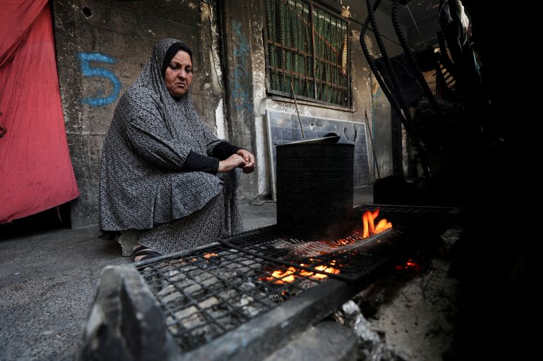 غزة تُعلن رسميا "منطقة مجاعة" جراء الحصار الإسرائيلي 8 FILE PHOTO: A woman cooks as she shelters in an UNRWA-affiliated school in Jabalia refugee camp, in the northern Gaza Strip, May 8, 2025. REUTERS/Mahmoud Issa/File Photo