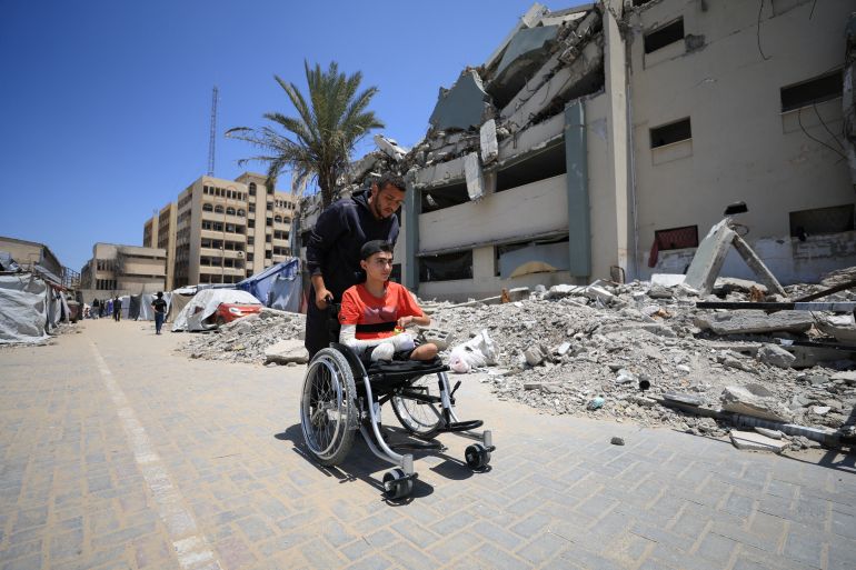 القصف الإسرائيلي يفقد لاعب جمباز ساقيه ويقتل حلمه 5 A Palestinian man pushes Ahmad Al-Ghalban, a 16-year-old Palestinian gymnast, who lost both his legs in an Israeli airstrike on Beit Lahiya, as he sits in his wheelchair, in Gaza City, May 21, 2025. REUTERS/Dawoud Abu Alkas
