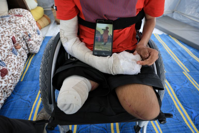 القصف الإسرائيلي يفقد لاعب جمباز ساقيه ويقتل حلمه 1 Ahmad Al-Ghalban, a 16-year-old Palestinian gymnast, who lost both his legs in an Israeli airstrike on Beit Lahiya, sits in his wheelchair as he shows his photo on a mobile phone, inside the tent where he took shelter after being displaced, in Gaza City, May 21, 2025. REUTERS/Dawoud Abu Alkas