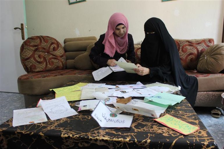 مشاهرة للجزيرة نت: لأول مرة أسمع كلمة "بابا" من أطفال نُطفي المهربة 4 _2-أسيل جندي، السواحرة الشرقية، سامية على يسار الصورة وزينة ابنتها على يمينها تقلبان الرسائل التي وصلتهما من فهمي خلال سنوات اعتقاله (أرشيف الجزيرة نت 2021)