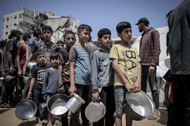 "عصابات الجوع بغزة" حيلة إسرائيلية جديدة أم سلاح إستراتيجي فتاك؟ 2 GAZA CITY, GAZA - MAY 31: Palestinians including women and children living in tents receive food distributed by aid organizations in al Mawasi district of Khan Yunis, Gaza on May 30, 2025. The situation highlights the growing desperation and urgent need for humanitarian assistance in the region. (Photo by Ahmed Jihad Ibrahim Al-arini/Anadolu via Getty Images)