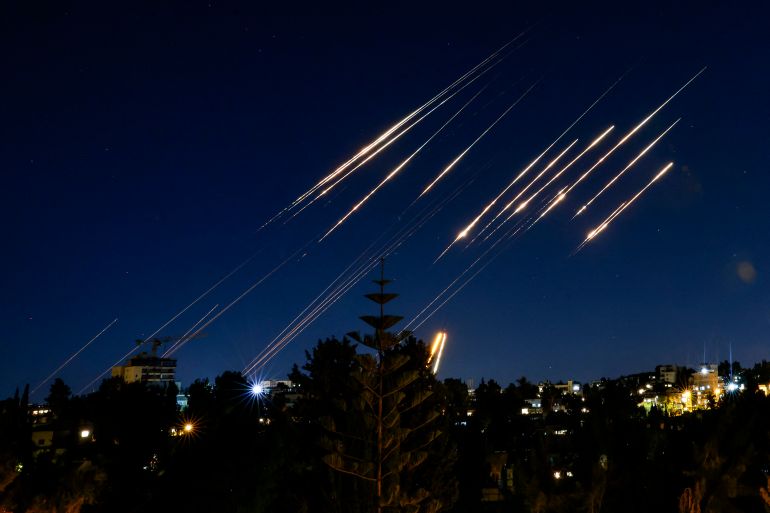 حلف تحصين إسرائيل يفشل أمام صواريخ إيران 2 Missiles fired from Iran are pictured in the night sky over Jerusalem on June 14, 2025. Israel and Iran exchanged fire on June 14, a day after Israel unleashed an unprecedented aerial bombing campaign that Iran said hit its nuclear facilities, "martyred" top commanders and killed dozens of civilians (Photo by Menahem Kahana / AFP)