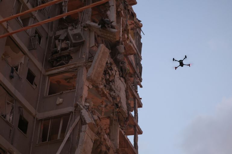 بالصور.. قصف إيران يدمر بات يام وفرق الإنقاذ تبحث عن ناجين 8 A drone flies beside a damaged building following a strike by an Iranian missile in the Israeli city of Bat Yam, south of Tel Aviv, early on June 15, 2025.