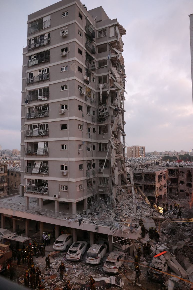 10 قتلى و180 مصابا حصيلة إسرائيلية للهجوم الإيراني أمس 1 People stand near a residential building that was hit following missile attack from Iran on Israel, at central Israel June 15, 2025. REUTERS/Tomer Appelbaum ISRAEL OUT. NO COMMERCIAL OR EDITORIAL SALES IN ISRAEL